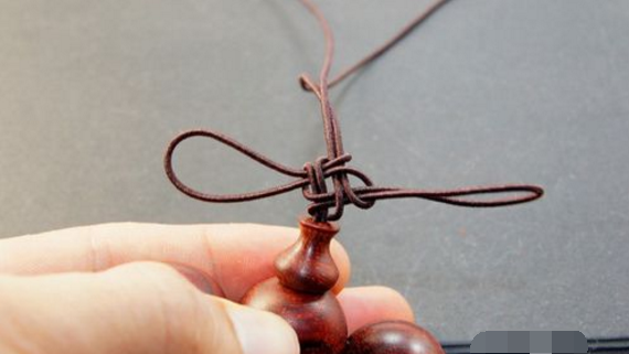红绳子的桃核手链那个结是怎么打的